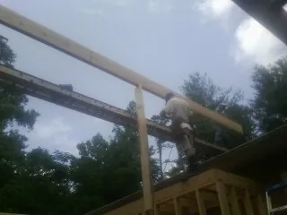 Carpenter setting a ridge beam over a new addition frame — Ice Dam Removal by Roofing Brothers in West Boylston