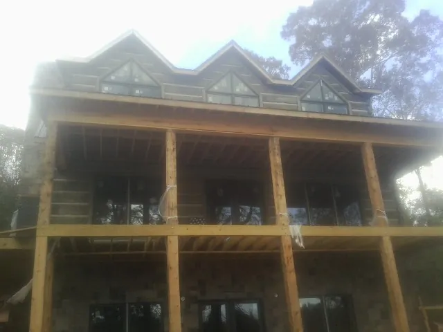 Dormers and porch framing on a large log home under construction — Roof Coating work by our crew in West Boylston