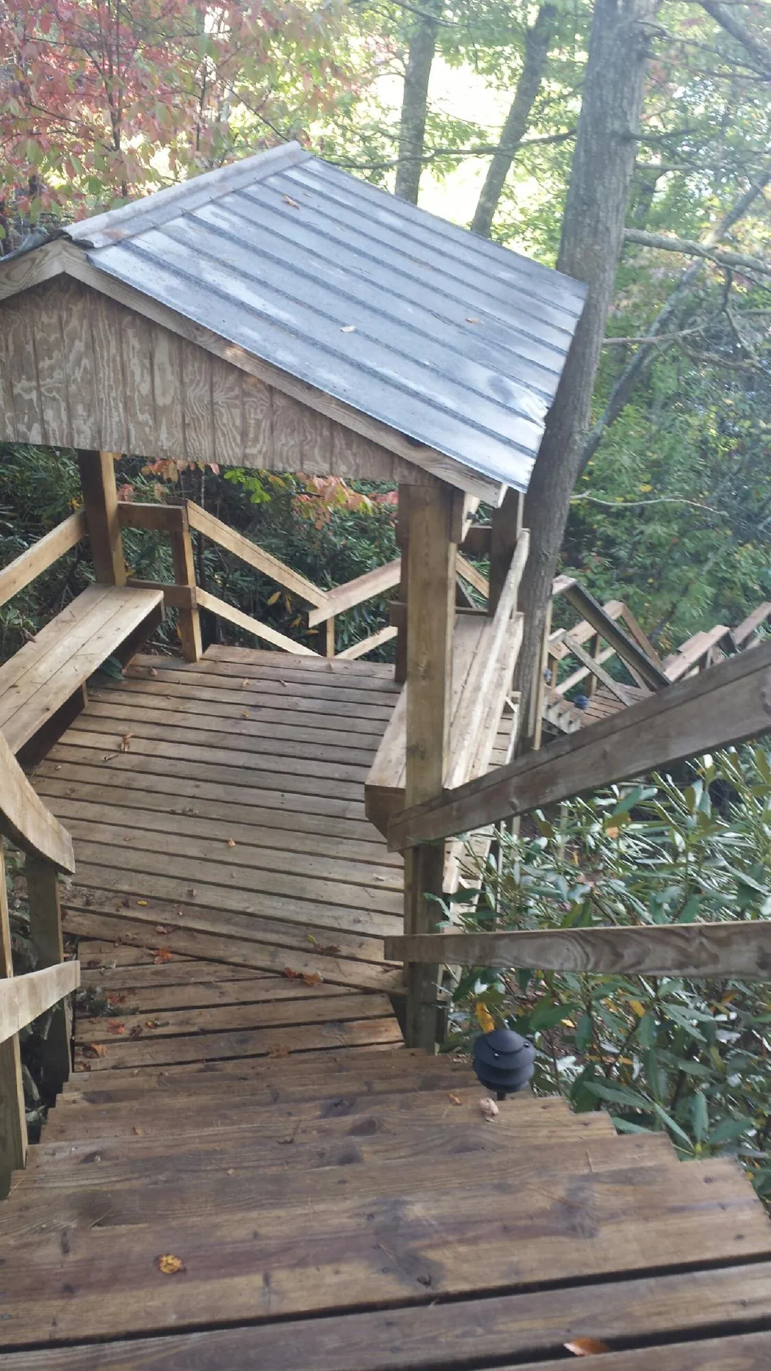 Metal roofed shelter over wooden steps on a wooded walkway — Skylight Repair & Installation work by our crew in West Boylston