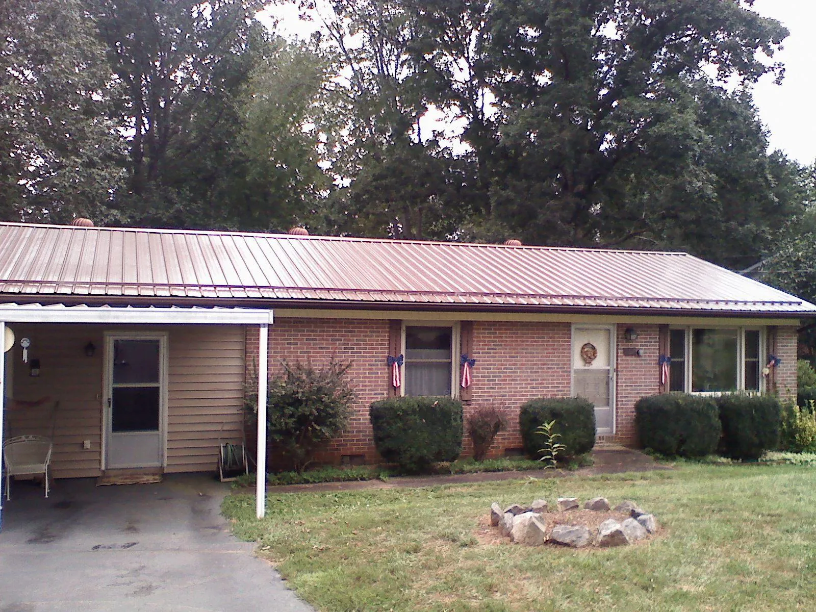 Bronze metal roof and carport on a brick ranch home — Roof Repair work by our crew in West Boylston